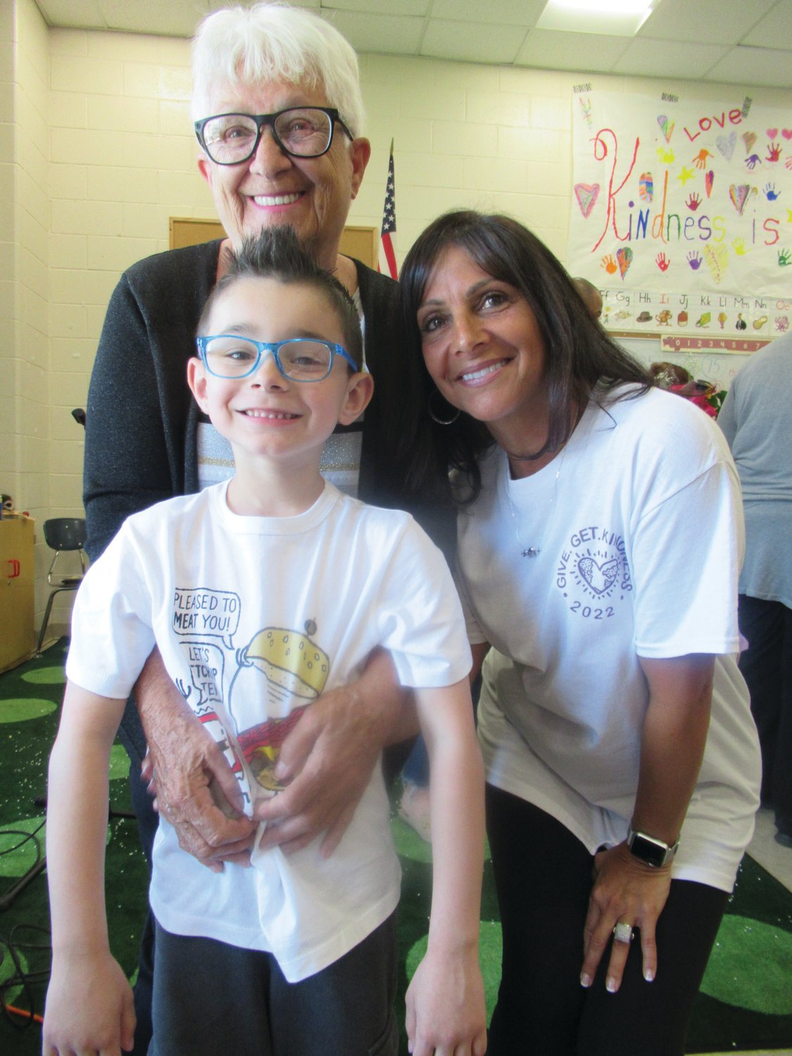 GRAM’S GUY: Lorie DeVito, former president of the once highly-active Manton Seniors hugs her grandson Anthony Pezzillo during last week’s Kindness celebration. They were joined by teacher/organizer Linda Greco.
